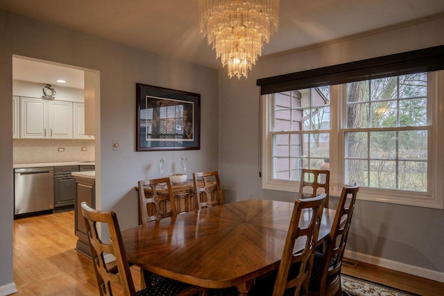 dining area with a chandelier and light wood-type flooring