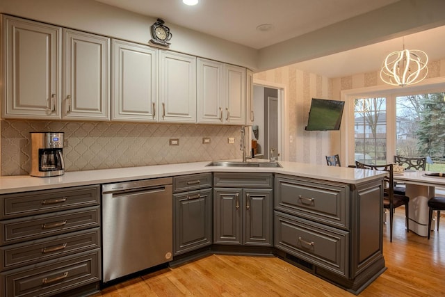 kitchen with pendant lighting, dishwasher, light hardwood / wood-style flooring, and sink