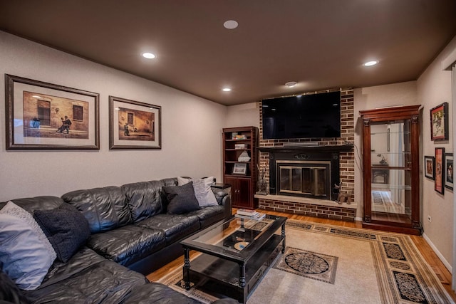 living room with hardwood / wood-style floors and a brick fireplace