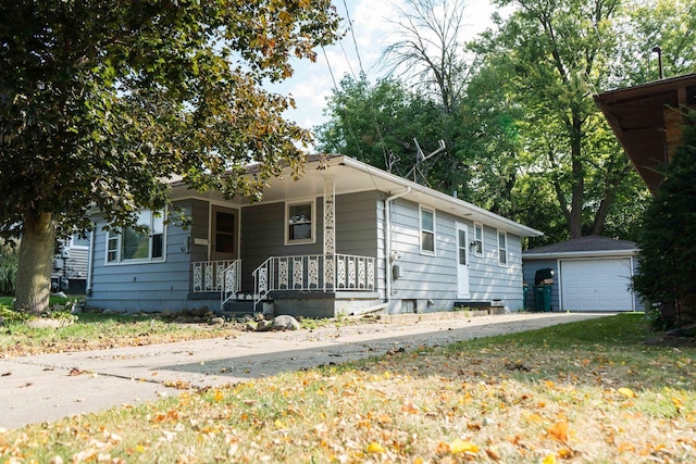 view of front of property featuring a porch, a garage, and an outbuilding