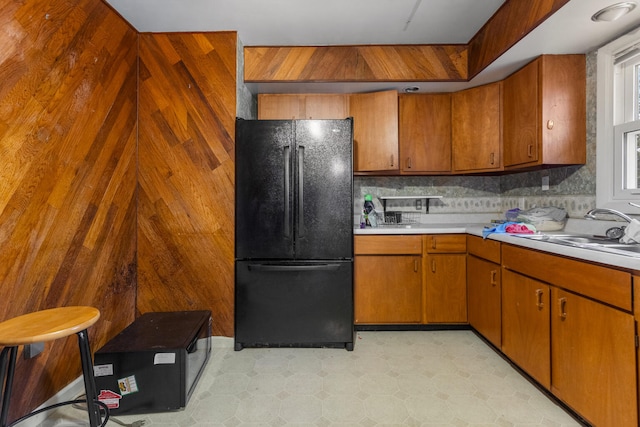 kitchen featuring backsplash, black fridge, and sink