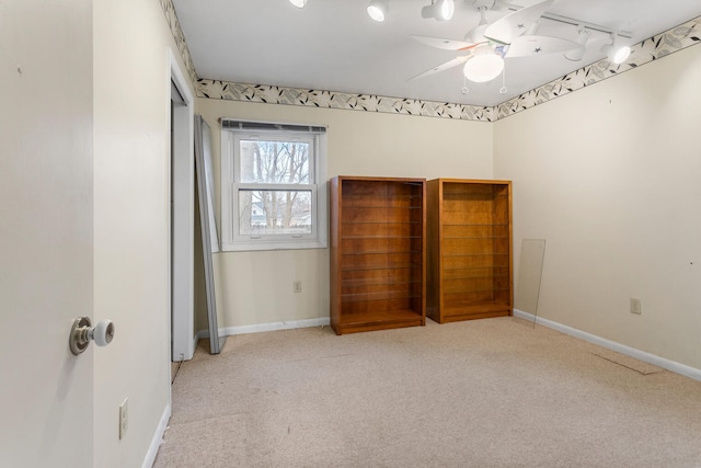 unfurnished bedroom featuring ceiling fan, light carpet, and track lighting