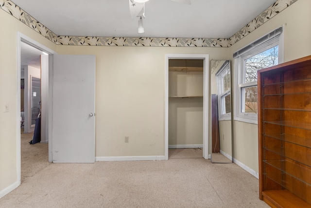 unfurnished bedroom featuring ceiling fan, light colored carpet, and a closet