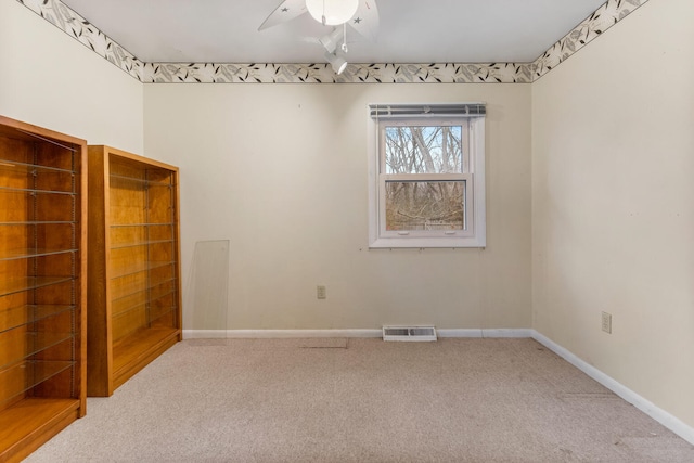 empty room featuring carpet floors and ceiling fan