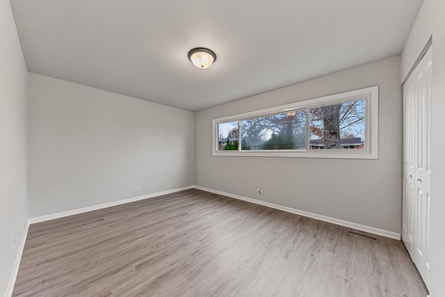 unfurnished bedroom featuring a closet and light wood-type flooring