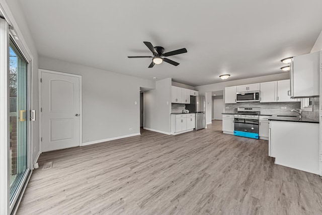 kitchen with ceiling fan, stainless steel appliances, light hardwood / wood-style flooring, decorative backsplash, and white cabinets