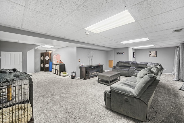 living room featuring carpet flooring and a drop ceiling