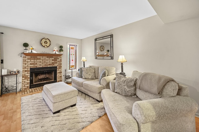 living room featuring wood-type flooring and a brick fireplace