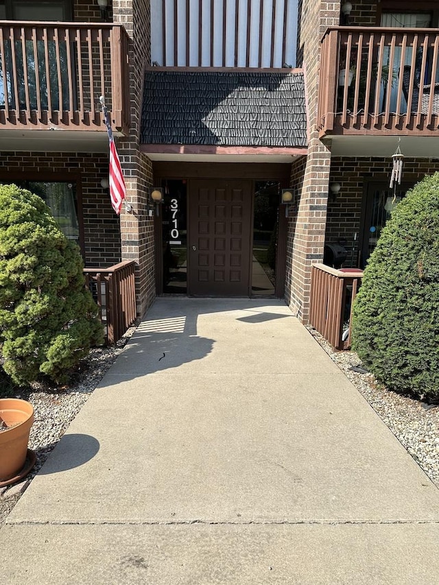 view of exterior entry with a balcony