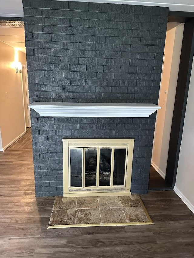 details with hardwood / wood-style flooring, crown molding, and a fireplace