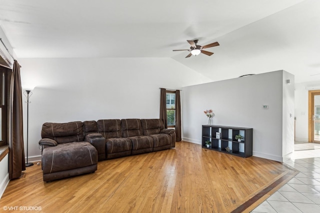 living room featuring ceiling fan, lofted ceiling, and light hardwood / wood-style flooring