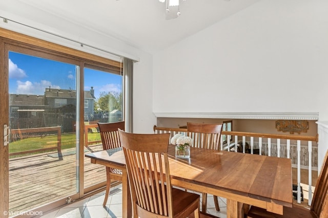 dining room with light tile patterned floors, vaulted ceiling, and ceiling fan