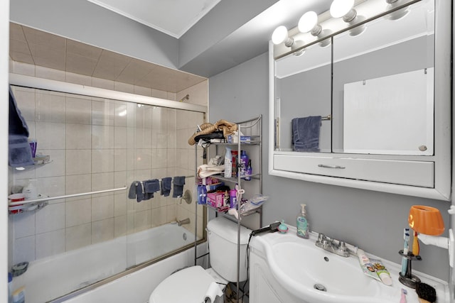 full bathroom with shower / bath combination with glass door, toilet, ornamental molding, and sink