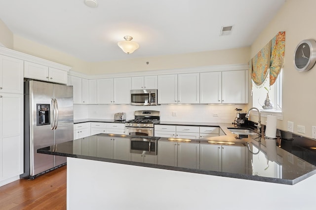11110 Waters Edge Dr Unit 4D, Orland Park, IL 60467 - kitchen with appliances with stainless steel finishes, a sink, a peninsula, white cabinetry, and wood finished floors
