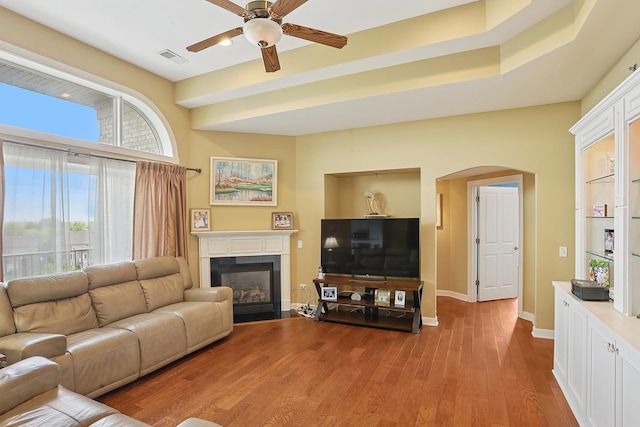 11110 Waters Edge Dr Unit 4D, Orland Park, IL 60467 - living room featuring arched walkways, a glass covered fireplace, ceiling fan, wood finished floors, and baseboards
