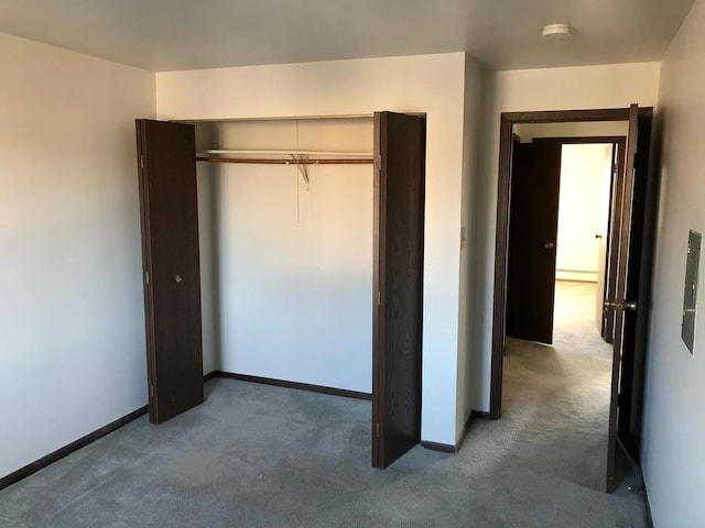 unfurnished bedroom featuring a closet, carpet floors, and a baseboard radiator