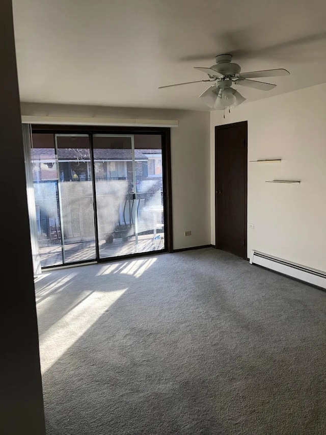 carpeted empty room with ceiling fan and a baseboard heating unit