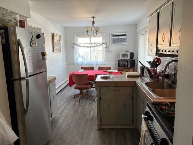 kitchen with a baseboard heating unit, sink, dark hardwood / wood-style floors, appliances with stainless steel finishes, and a chandelier