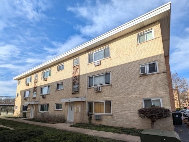 view of building exterior featuring central AC and a wall mounted air conditioner