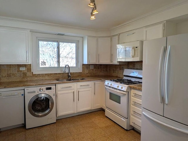 kitchen with sink, crown molding, white appliances, washer / dryer, and white cabinets