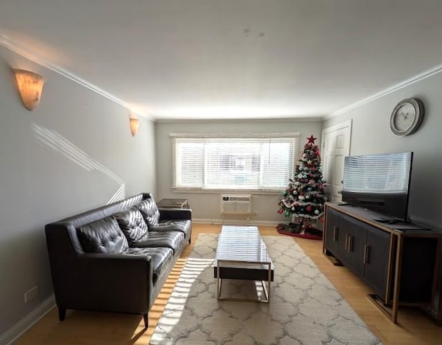 living room with light hardwood / wood-style floors, ornamental molding, and an AC wall unit