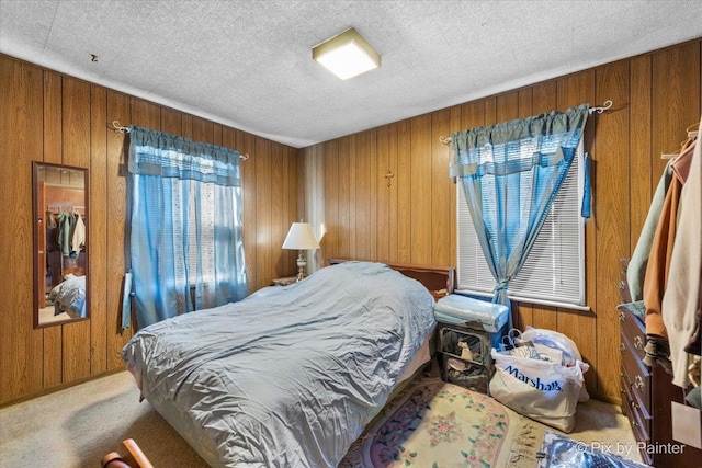 bedroom with wood walls, carpet, and a textured ceiling