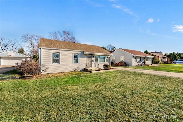 view of front of house featuring a front lawn, an outdoor structure, and a garage