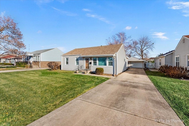 view of front of home featuring an outdoor structure, a front yard, and a garage