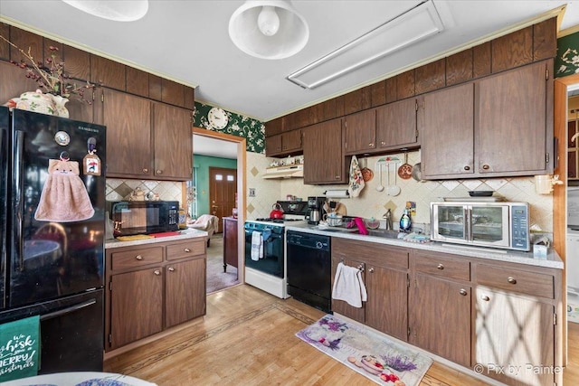 kitchen featuring exhaust hood, black appliances, light hardwood / wood-style flooring, decorative backsplash, and dark brown cabinets