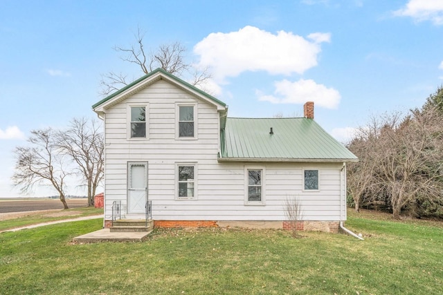 rear view of property with a lawn