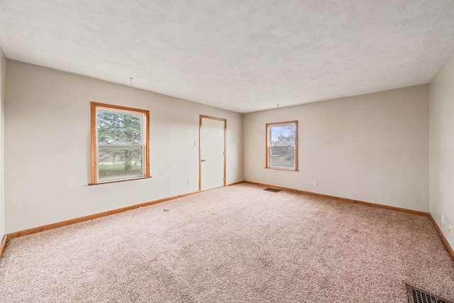 unfurnished room featuring carpet floors and a textured ceiling