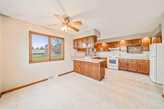 kitchen with ceiling fan, sink, white appliances, and kitchen peninsula