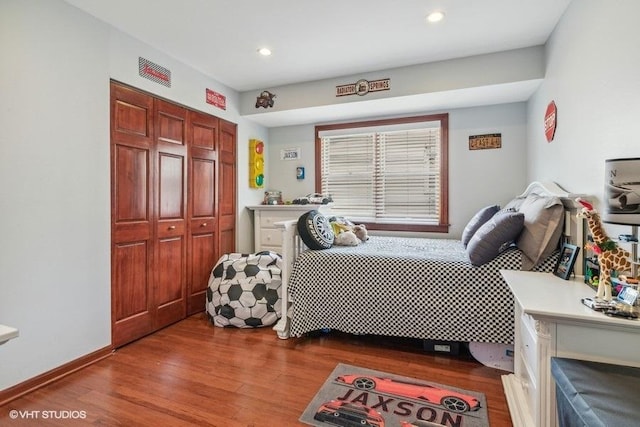 bedroom featuring a closet, recessed lighting, and wood finished floors