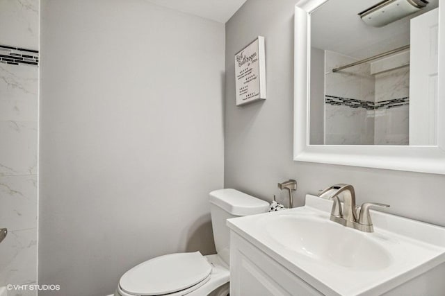 bathroom featuring a shower, vanity, and toilet