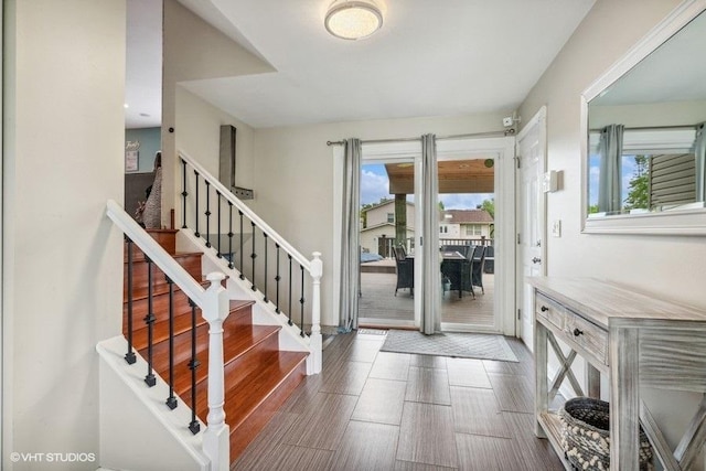 entrance foyer with a healthy amount of sunlight, wood finished floors, and stairway