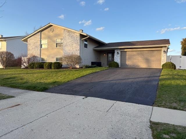 tri-level home with an attached garage, driveway, and a front yard