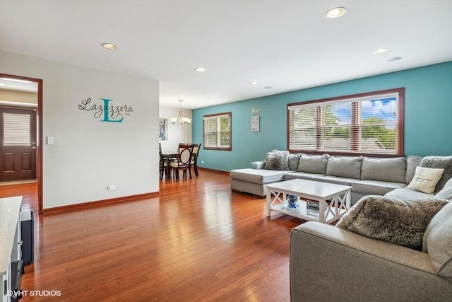 living area featuring baseboards, recessed lighting, an inviting chandelier, and wood finished floors