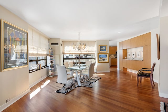 dining area with hardwood / wood-style floors and an inviting chandelier