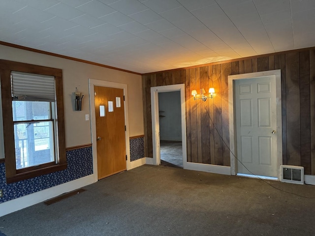 interior space featuring wood walls and crown molding