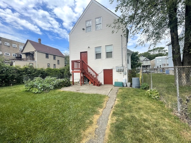 rear view of property with a patio area and a lawn