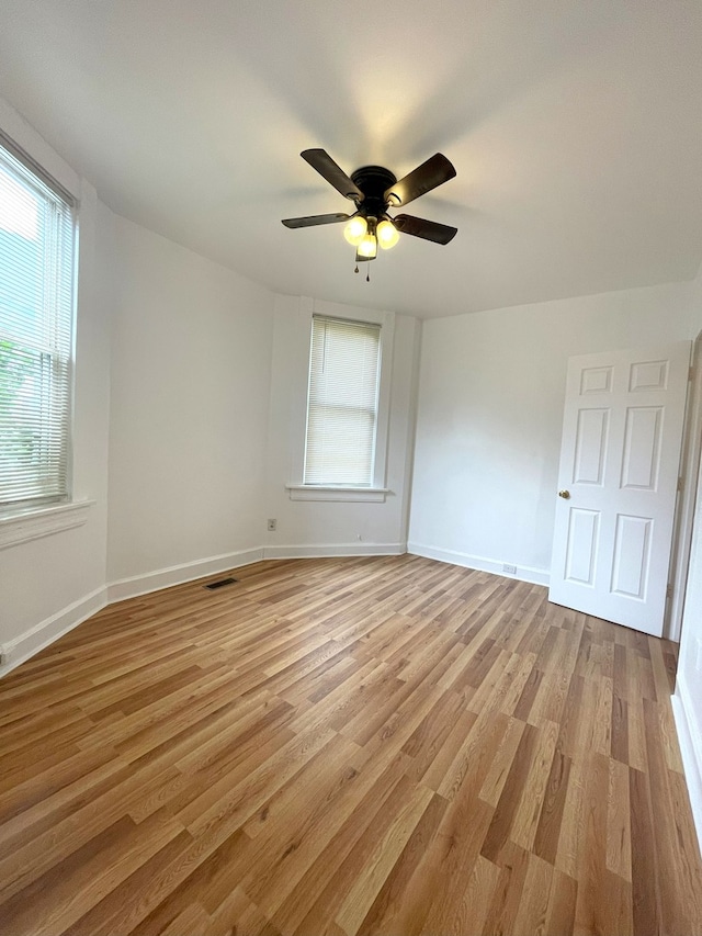 empty room with ceiling fan and light wood-type flooring