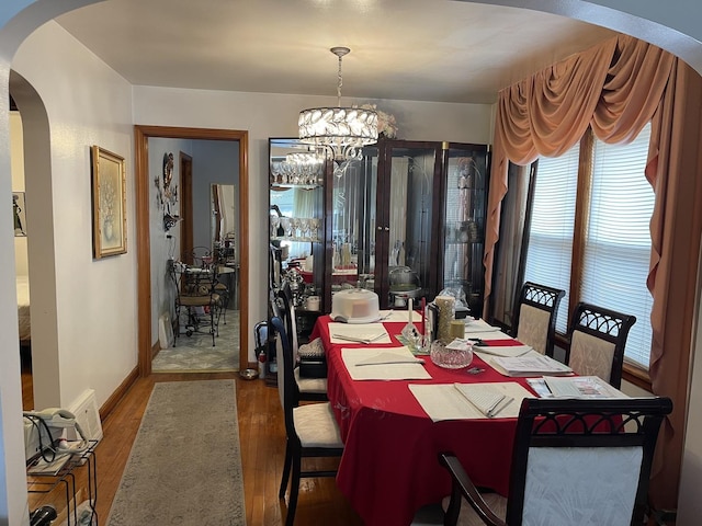 dining space with an inviting chandelier and hardwood / wood-style flooring