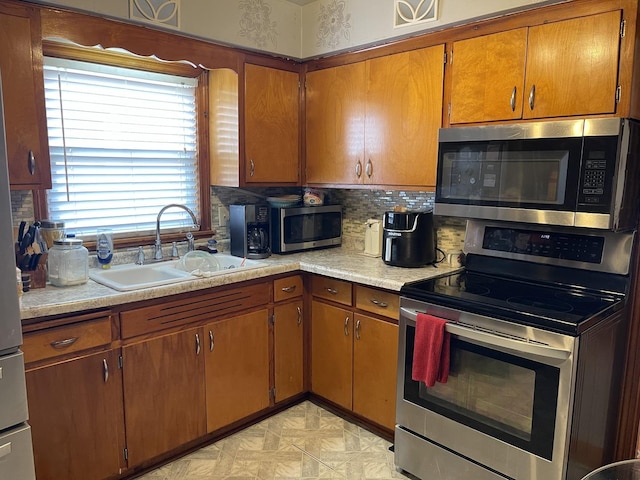 kitchen featuring stainless steel appliances, tasteful backsplash, and sink