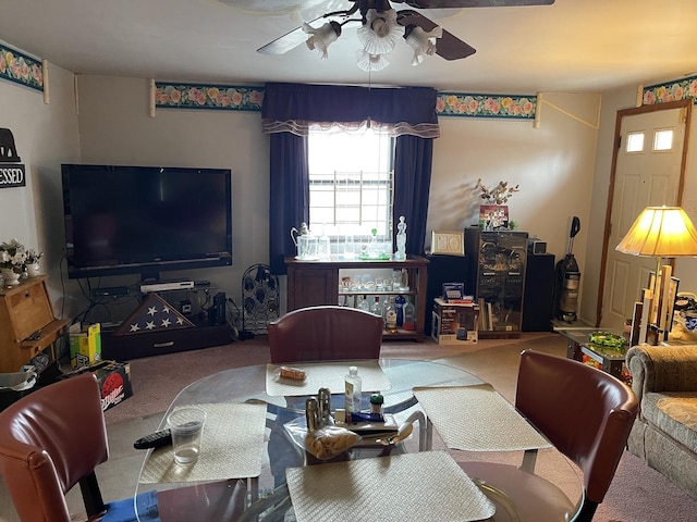 carpeted dining area with ceiling fan