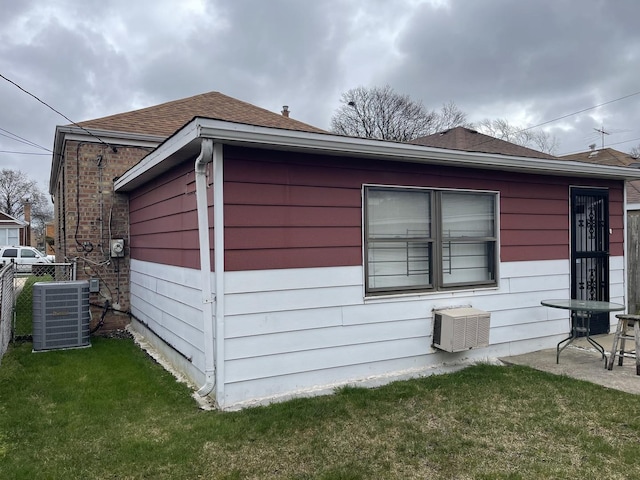 view of side of home with a lawn and cooling unit