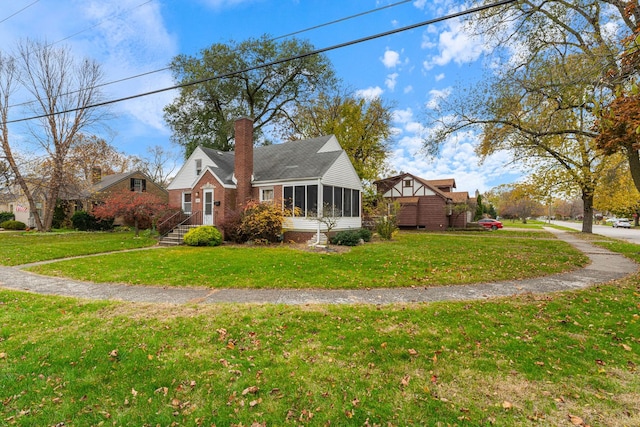 view of front of home with a sunroom and a front lawn