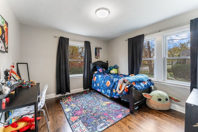 bedroom with hardwood / wood-style floors and multiple windows