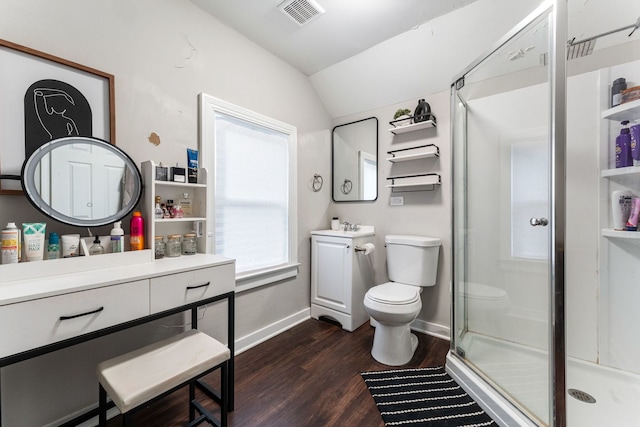 bathroom with hardwood / wood-style floors, vanity, vaulted ceiling, toilet, and a shower with shower door