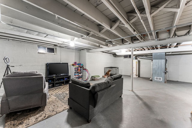 living room with heating unit, concrete flooring, and gas water heater