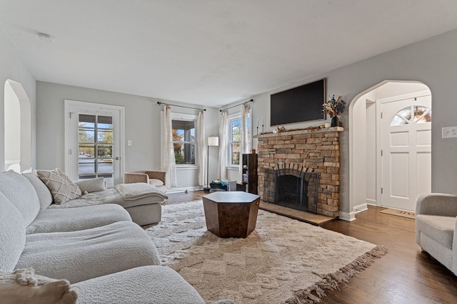 living room featuring a fireplace, dark hardwood / wood-style floors, and plenty of natural light